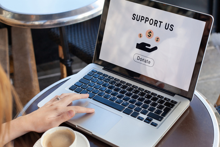 Laptop on a table showing a charity website donation page